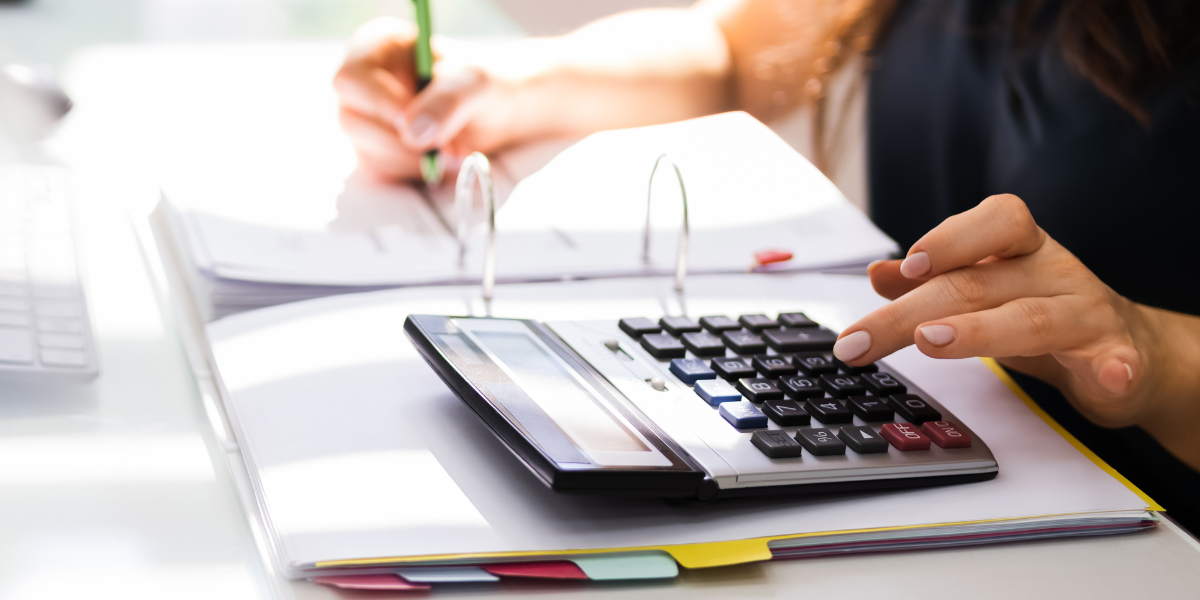 A person is using a calculator and taking notes